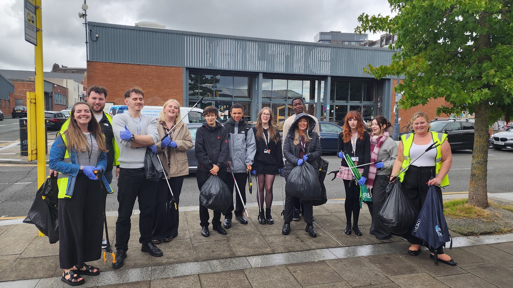 Image of group of sixth from students on a litter picking activity, alongside Head of Sixth Form and staff member from Baltic Creative.